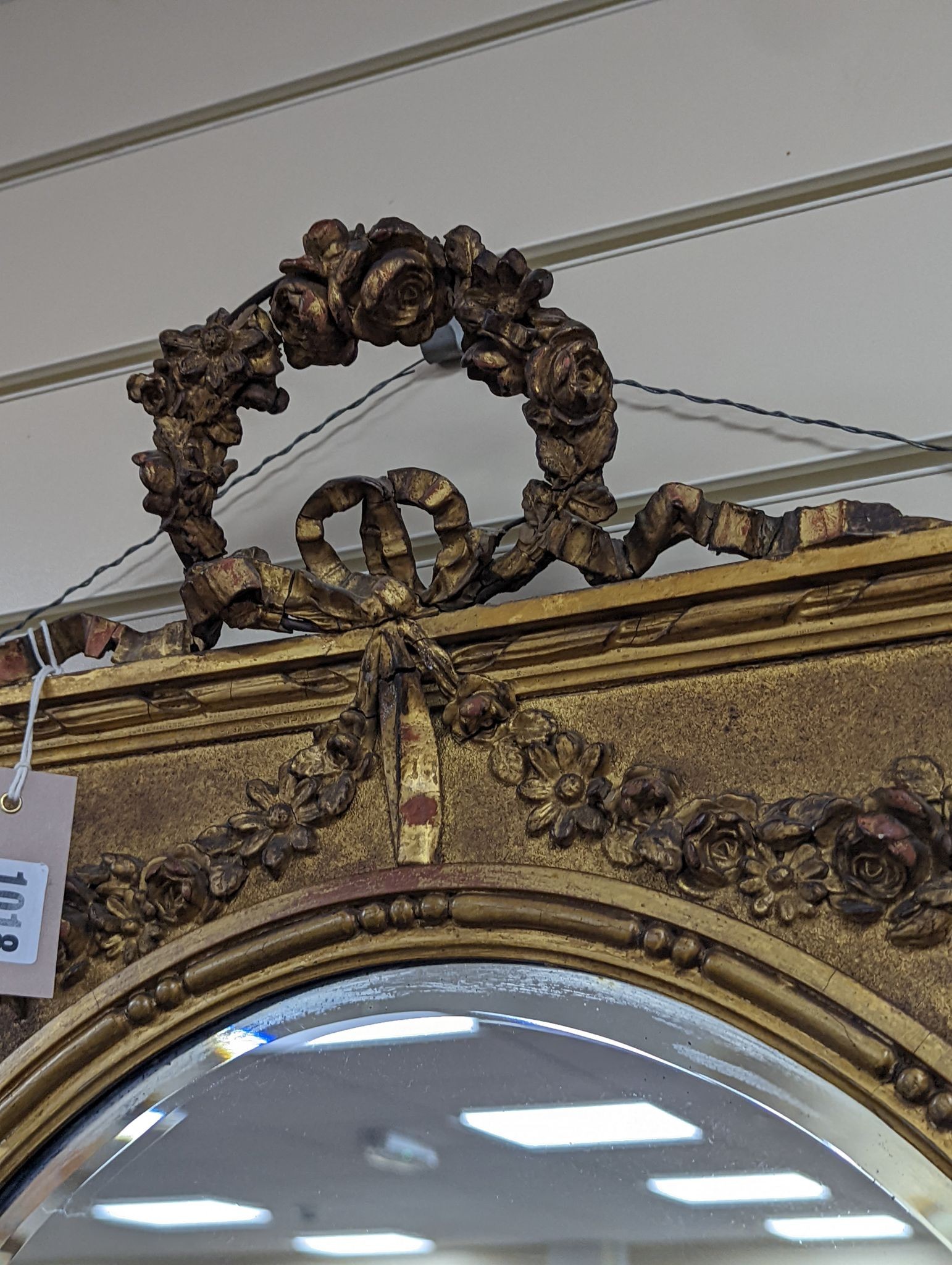 A Victorian style rectangular giltwood and gesso wall mirror, floral swag to top, with oval plate, width 70cm, height 92cm